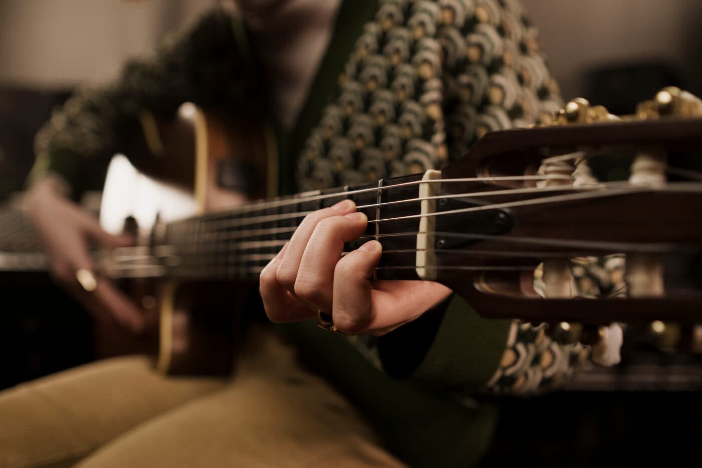 Primer plano de una mano tocando una guitarra eléctrica en una sesión de jam.